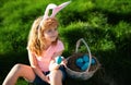 Easter children. Happy Easter. Kids in bunny ears with Easter egg in basket. Boy play in hunting eggs.