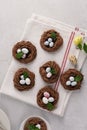 Easter chocolate cookies in the shape of Nests with sweet eggs on white napkin with mint leaves. top view Royalty Free Stock Photo