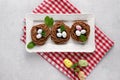 Easter chocolate cookies in the shape of Nests with sweet eggs on white plate on red napkin with mint leaves. top view Royalty Free Stock Photo