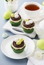 Easter chocolate cupcakes with nest, candy eggs and tea Royalty Free Stock Photo