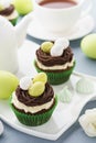 Easter chocolate cupcakes with nest, candy eggs and tea Royalty Free Stock Photo