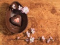 Easter chocolate egg with a surprise of a decorated heart ,sprinkled with cocoa powder and accompanied with almond blossom. Royalty Free Stock Photo