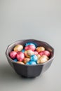 Easter chocolate eggs wrapped in aluminium foil in bowl on gray background Royalty Free Stock Photo