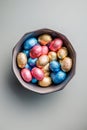 Easter chocolate eggs wrapped in aluminium foil in bowl on gray background. Top view Royalty Free Stock Photo