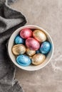 Easter chocolate eggs wrapped in aluminium foil in bowl on kitchen table. Top view Royalty Free Stock Photo