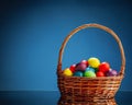 Easter color eggs in festive gift basket, blue background