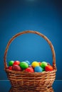 Easter color eggs in festive gift basket, blue background