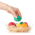 Easter color eggs in the nest in hand