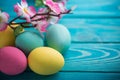 Easter colored eggs with lace ribbon and flowers on blue wooden background Royalty Free Stock Photo