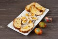 Easter colored eggs and sliced Easter bread in white plate on grey wooden board. Royalty Free Stock Photo