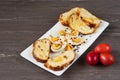 Easter colored eggs and sliced Easter bread in white plate on grey wooden board. Royalty Free Stock Photo