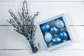 Easter colored eggs in square cardboard box and willow branches on wooden backdrop. Trendy toning in classic blue Royalty Free Stock Photo