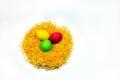 Easter colored eggs in yellow straw nest isolated on white background Royalty Free Stock Photo