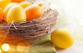 Easter colorful eggs in the nest. Beautiful painted, colorful yellow and orange color eggs with decorations on white wooden table