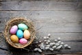 Easter colorful eggs in the nest with flowers on vintage wooden boards and empty space Royalty Free Stock Photo