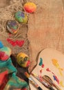 Easter colorful eggs with two painter's brushes,a wooden palette and a hand painted cloth. Royalty Free Stock Photo