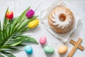 Easter colorful spring tulips with palm cross cake and eggs decoration on white wooden natural background