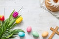 Easter colorful spring tulips with palm cross cake and eggs decoration on white wooden natural background Royalty Free Stock Photo