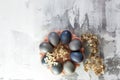 Easter composition from blue eggs, cake forms, tree branches, dry flowers and candles on concrete background