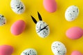 Easter composition with colored eggs and egg with bunny ears and face on yellow background