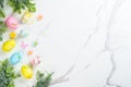 Easter composition with colored eggs and green plants on white background. Royalty Free Stock Photo