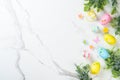 Easter composition with colored eggs and green plants on white background. Royalty Free Stock Photo