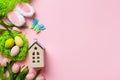 Easter composition. Colorful eggs in nest tulip flowers bunny ears toy house on pink background copy space Royalty Free Stock Photo