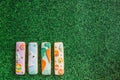 Easter composition with easter cookies painted sticks on green grass background. Easter concept with copy space. Flat lay