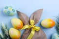 Easter composition with craft paper package in the shape of bunny, colorful easter eggs, and flowers. Top view, copy spa Royalty Free Stock Photo