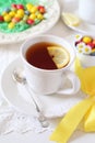 Easter composition: cup of lemon tea drink with colorful candy Royalty Free Stock Photo