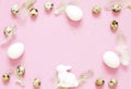 Easter composition with easter eggs,rabbit and feathering on pink background, space for text Royalty Free Stock Photo