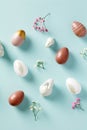 Easter composition. Easter eggs, flower, decorative rabbits on pastel blue background. Flat lay, top view