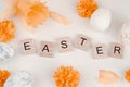 Easter composition of flowers and eggs. Easter word on wooden cubes. Easter composition of flowers and eggs