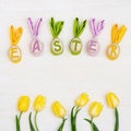 Easter composition with handmade colored eggs with ears from rabbit and word Easter is made of colorful letters Royalty Free Stock Photo