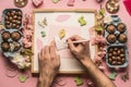 Easter composition, men`s hands sign postcard, around are lined with various chocolate eggs, decorations and toys, top view flat