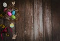Nest with colored eggs, wooden decorative Easter figurines and forsythia branches on a wooden background. Royalty Free Stock Photo