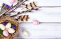 Easter composition with a nest, eggs and branches on wooden table. Royalty Free Stock Photo