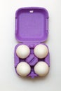 Easter composition. Set of Four white eggs in purple box on white background Royalty Free Stock Photo