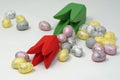 Easter composition. Mini eggs in pastel colors and a wooden tulip. White background.