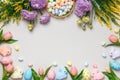 Easter composition. Top view frame of eggs in basket purple yellow flowers on gray background Royalty Free Stock Photo