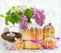 Easter composition with traditional Russian Easter bread kulich, Easter eggs and lilac flowers