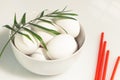 White chicken eggs in a white bowl with red church candles Royalty Free Stock Photo