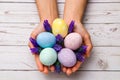 Easter concept. closeup beautiful woman hands holding hand-painted easter eggs in tender pastel colors and lavender flowers over Royalty Free Stock Photo
