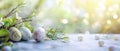 Easter concept with colored eggs on a white table in the garden. Blurred, sunny, green and yellow background with copyspace Royalty Free Stock Photo