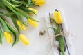 Easter concept with copy space. Decorative easter place setting with yellow tulip, a quail egg on a white.