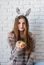 Cute woman in bunny ears holding a small nest with an egg in her hand Royalty Free Stock Photo