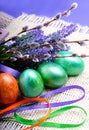 Painted green and orange eggs with lavender and willow on a burlap background