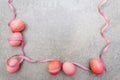 Easter concept pink rosy eggs with satin polka dot ribbons in sunny rays. On stone background. Frame Royalty Free Stock Photo