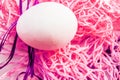 Easter concept, white egg on neon pink background, woven fabric nest, top view, copy space, modern design Royalty Free Stock Photo