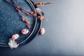 Easter decor. Close up of dishes with eggs, feathers and spring branches. Ceramic plates on grey background. Space Royalty Free Stock Photo